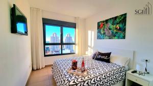 a bedroom with a bed and a window with a view at SUNSET Chill Out- Torres D' Oboe in Benidorm