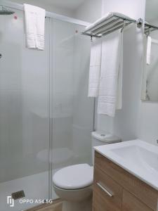a white bathroom with a toilet and a shower at Texeda Room Suites in Tejeda