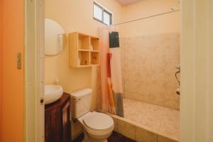 y baño con aseo, lavabo y ducha. en Habitat Surf Glamp en Santa Teresa