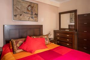 una camera con un letto con una coperta rossa e arancione di CASA SALMÓN a Cadice