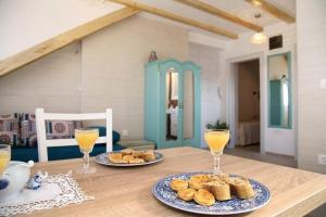 une table avec deux assiettes de nourriture et deux verres de jus d'orange dans l'établissement Apartment Barbara's Inheritance, à Split