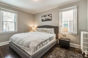 a bedroom with a large bed and two windows at Cute and Quiet Sleeps 10~15mins Downtown Detroit in Detroit
