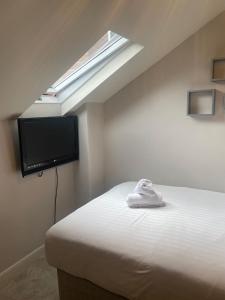 a bedroom with a bed with a skylight and a television at Gregory by the Warren Collection in Belfast