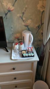 a white dresser with a tray with a coffee maker on it at Gregory by the Warren Collection in Belfast
