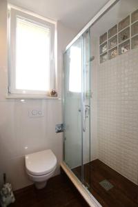 a bathroom with a toilet and a glass shower at Apartment Barbara's Inheritance in Split