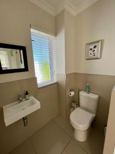 a bathroom with a toilet and a sink at Kingswood Close in George