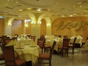 Hotel Class في كونستانتا: مطعم به طاولات وكراسي مغطاة بمفارش بيضاء