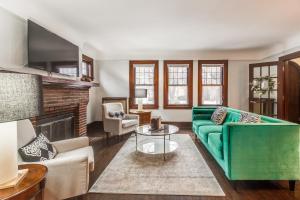 a living room with a green couch and a fireplace at NEWHOST-Victorian Pintrest Style 15min to Downtown in Detroit