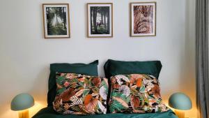 a bedroom with a bed with two pictures on the wall at La petite forêt in Romorantin