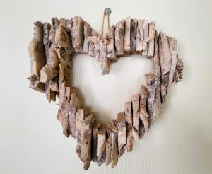 a wooden heart shaped wreath hanging on a wall at La petite forêt in Romorantin