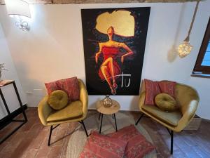 - un salon avec deux chaises et un tableau mural dans l'établissement Casa Porta Fontevecchia panoramica, à Spello