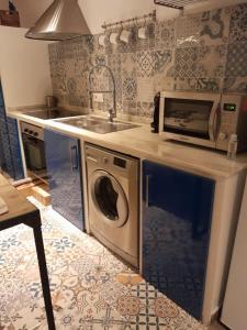 une cuisine avec un micro-ondes et un lave-linge dans l'établissement La Herrería de Sagasta, à Cadix 7 autres photos
