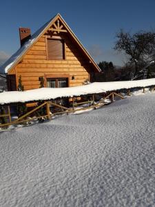 Cabaña de madera con nieve en el suelo en Domek Góralski Piwowarówka, en Piwniczna-Zdrój