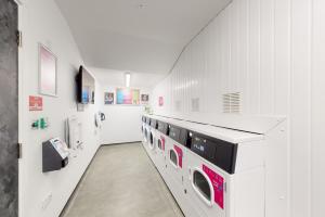 a laundry room with a row of washing machines at Premium Studios at Chapter Westminster in London minutes away from The Big Ben in London