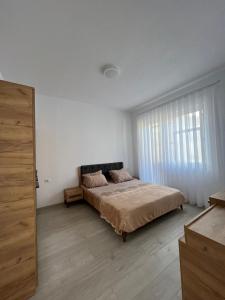 a bedroom with a bed and a large window at Apartment in Peja city center in Peje