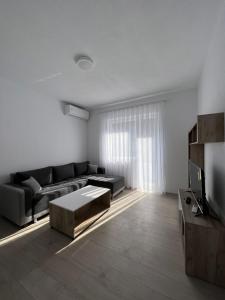 a living room with a couch and a tv at Apartment in Peja city center in Peje