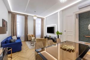 a living room with a blue couch and a tv at Luxurious Bajcsy Residence next to the Basilica in Budapest