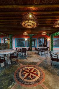 a dining room with tables and chairs and a chandelier at Refúgio do Rio Bonito in Bonito