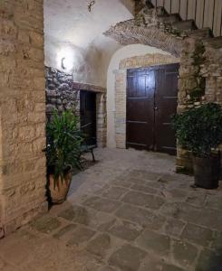 un couloir en pierre avec une grande porte en bois dans un bâtiment dans l'établissement Lo Stemma B&B Guest House, à Melfi