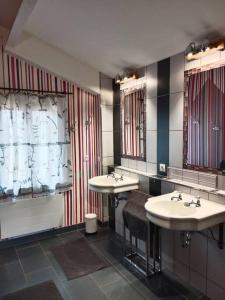 a bathroom with two sinks and two mirrors at Maison a la campagne in Saint-Pierre-de-Chevillé