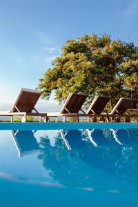 a group of lounge chairs and a swimming pool at Refúgio do Rio Bonito in Bonito