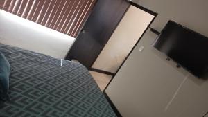 a bedroom with a bed and a flat screen tv at Suites Entrelagos in Ciudad Obregón