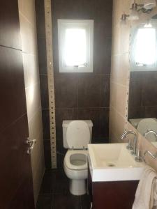 uma casa de banho com um WC, um lavatório e uma janela em Hermoso departamento en Chivilcoy em Chivilcoy