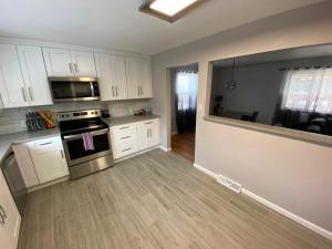 una cucina con mobili bianchi e un forno a piano cottura di 2br 1 bath Upstairs AC WD Barnum West Near Belmar a Denver Altre 12 foto
