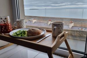 a plate of food on a table next to a window at Seaview cottage North Wales in Penmaen-mawr
