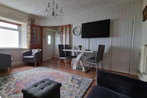 a living room with a table and a tv at Seaview cottage North Wales in Penmaen-mawr