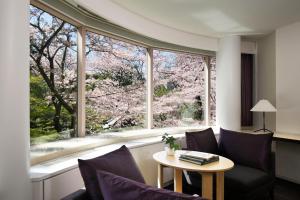 a living room with a table and a large window at The Prince Sakura Tower Tokyo, Autograph Collection in Tokyo