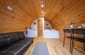 a living room with a couch in a wooden ceiling at Woodside Pod in Fort William