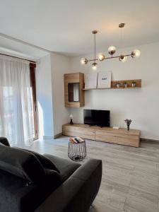 a living room with a couch and a television at Apartamentos CEO - Naranja in Ronda