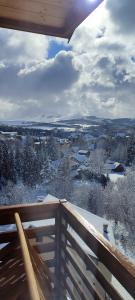 een balkon met uitzicht op een met sneeuw bedekte stad bij Golden View Zlatibor in Zlatibor