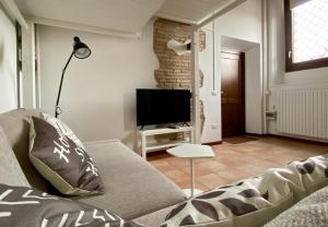 sala de estar con sofá y TV en Il Barchio loft in un palazzo di fine 800 a Jesi, en Iesi