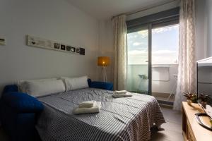 Un dormitorio con una cama azul con toallas. en POSEIDON Beach Apartment & parking by Cadiz4Rentals, en Cádiz