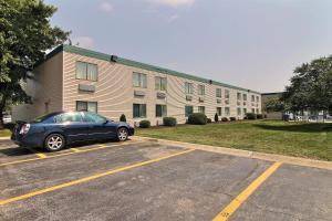 a car parked in a parking lot in front of a building at Motel 6-Merrillville, IN in Merrillville
