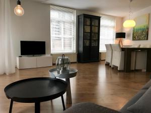 uma sala de estar com um sofá e uma mesa em Hotel Tongerlo em Roosendaal