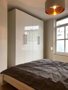 a bedroom with white cabinets and a large bed at Hotel Tongerlo in Roosendaal