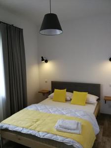 una camera da letto con un grande letto con cuscini gialli di Domek przy lesie 2 a Danzica