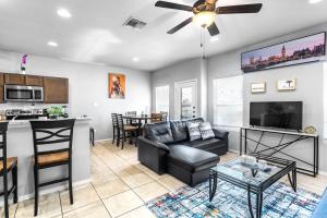 a living room with a couch and a table at Oversized Modern 3BR 3BA Home w 12 Arcade Games & HotTub- 5mins to Airport w Private Garage in San Antonio