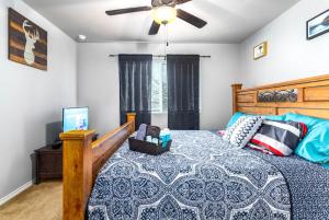 Schlafzimmer mit einem Bett und einem Deckenventilator in der Unterkunft Texas style 3BR 3BA Home w 12 Arcade Games & HotTub- 5mins to Airport w Private Garage in San Antonio