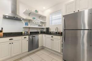 a kitchen with white cabinets and a stainless steel refrigerator at Sleep 10 next to Superdome and downtown in New Orleans