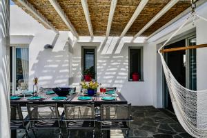 un tavolo e sedie su un patio con amaca di Villa in Kamares, Sifnos a Kamárai