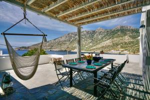 a patio with a hammock and a table and chairs at Villa in Kamares, Sifnos in Kamares