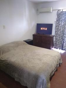 戈多伊克魯斯的住宿－Siddhi hum，卧室配有一张床,墙上挂有网状标志