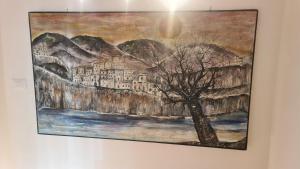 a painting hanging on a wall with a tree at Affittacamere cosulich in Monfalcone