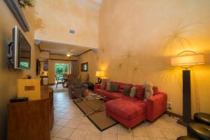 un soggiorno con divano rosso e TV di Los Suenos Resort Veranda 1B by Stay in CR a Herradura
