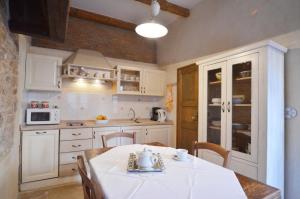 a kitchen with white cabinets and a table with chairs at House Trevisol in Rovinj