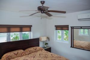a bedroom with a bed and a ceiling fan at Seascape Villa in Montego Bay